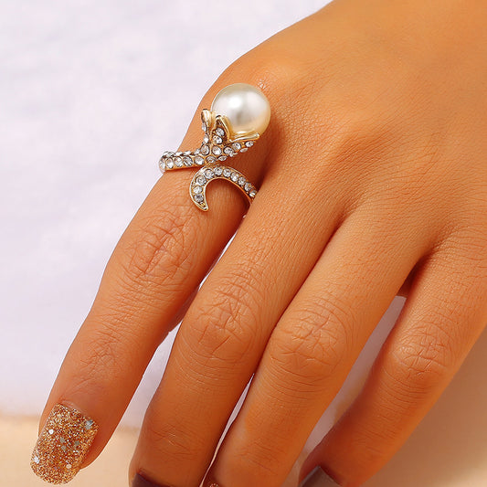 Bague perle fleur Moyyudé avec perle blanche et cristaux brillants sur doigt féminin