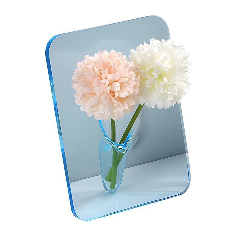 Vase acrylique transparent Moyyude avec deux fleurs pastel sur fond bleu clair